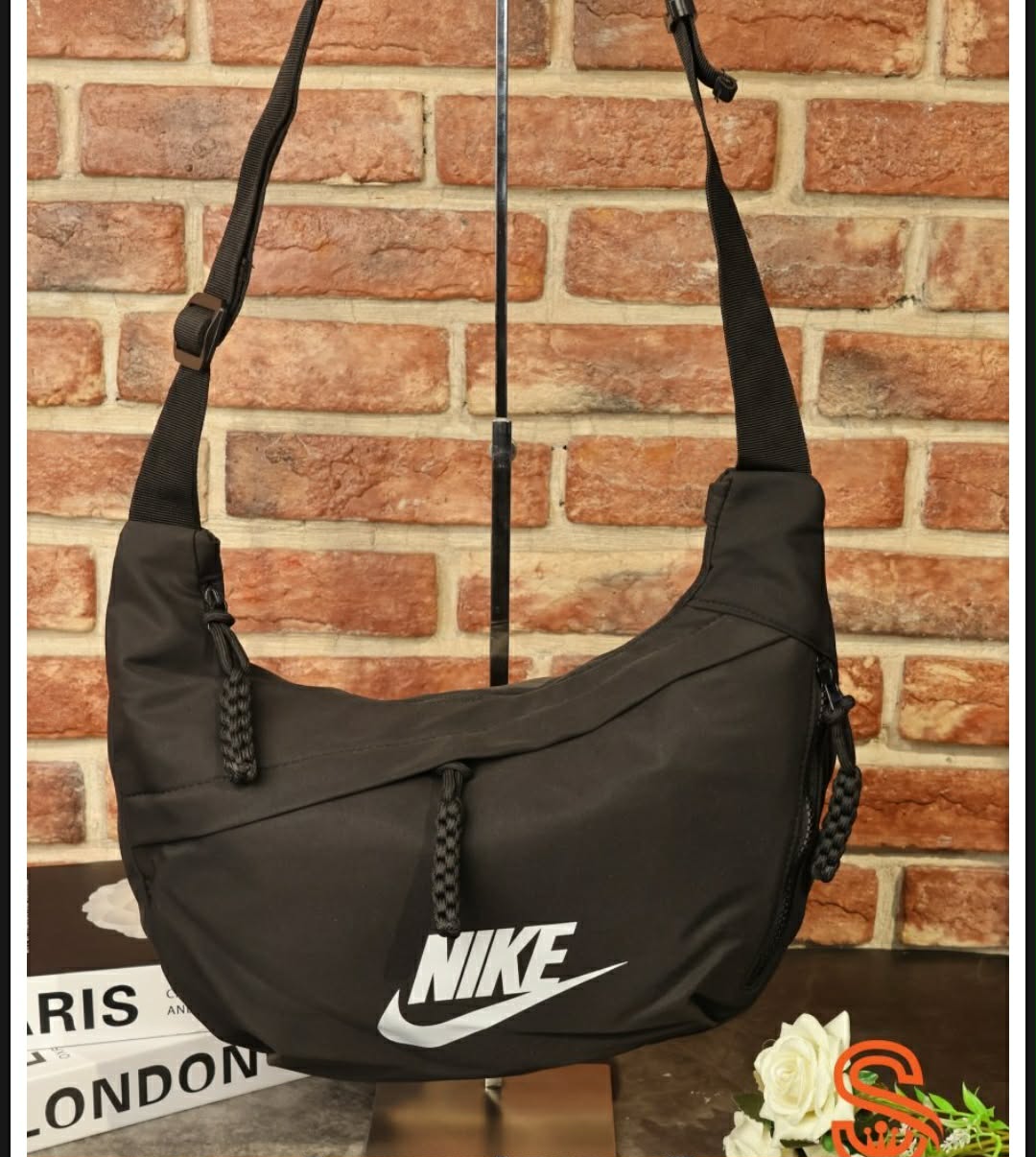 حقيبة كتف هلالية الشكل (Crescent Crossbody Bag) تحمل شعار علامة نايكي (Nike).
