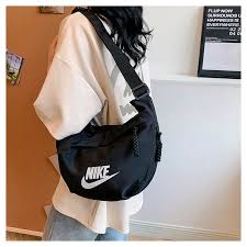 حقيبة كتف هلالية الشكل (Crescent Crossbody Bag) تحمل شعار علامة نايكي (Nike).
